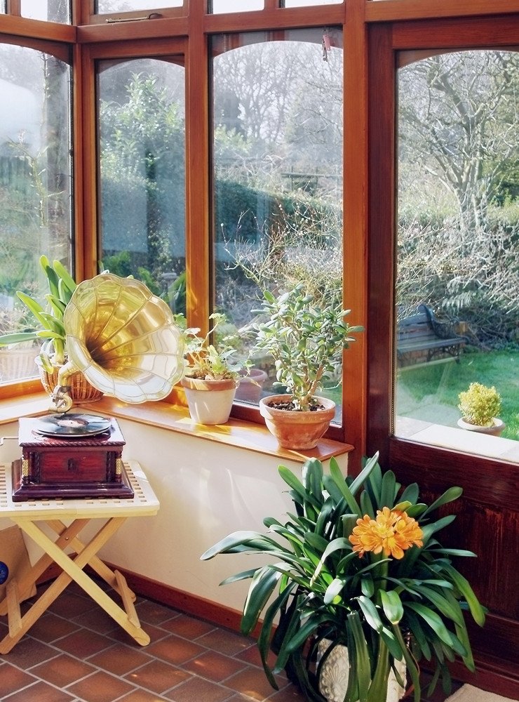 Остекленная веранда в частном доме, комнатные растения, плитка на полу