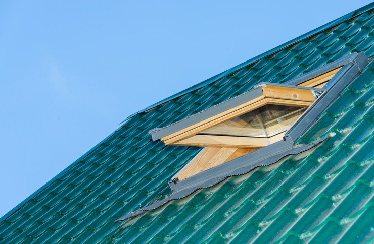 Приоткрытое мансардное окно в зеленой крыше