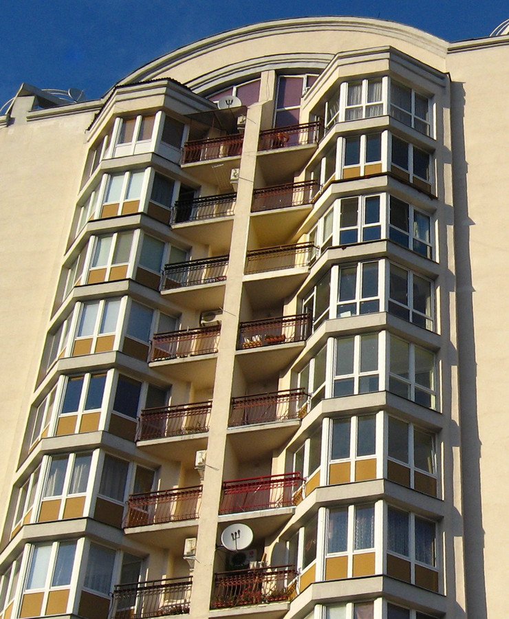 Балконные блоки полукругом с остеклением в современном многоэтажном доме