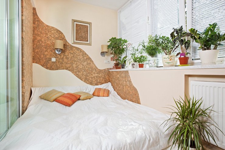 Остекленная комната, диван-кровать с подушками, батарея, комнатные цветы