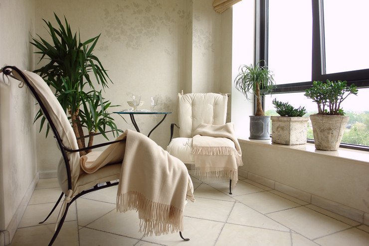 Остекленный балконный блок, два стула с пледами, комнатные растения