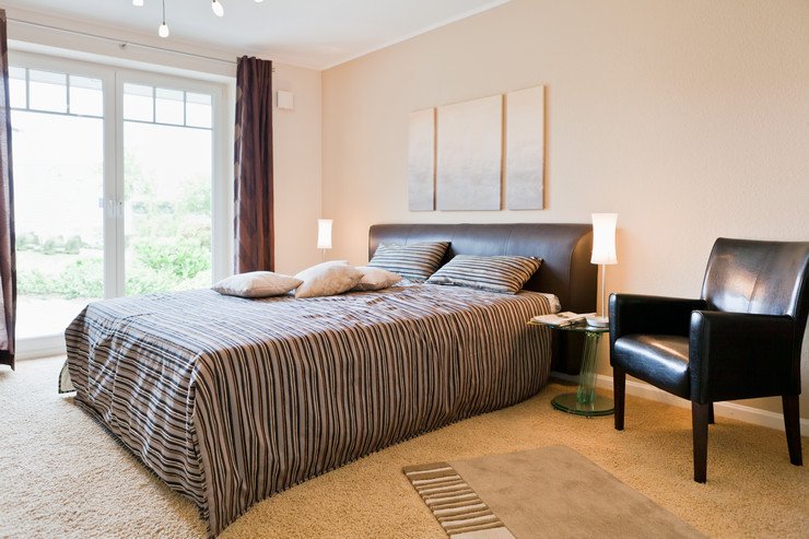 Панорамное остекление в просторной спальне, кровать, кресло, мягкий ковролин на полу