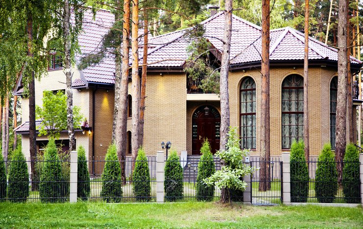 Остекленный арочными пластиковыми окнами большой кирпичный загородный дом