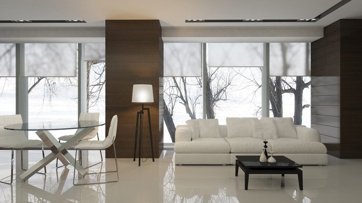 Остекленная панорамными оконными системами гостиная, диван, стулья, стол