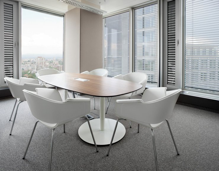 Остекленный панорамными окнами офис, стол, белые стулья
