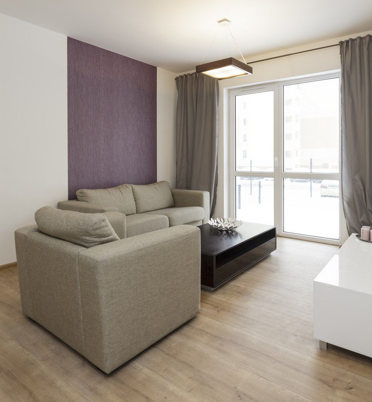 Остекленная панорамными евроокнами комната, мягкий диван, стол, шторы