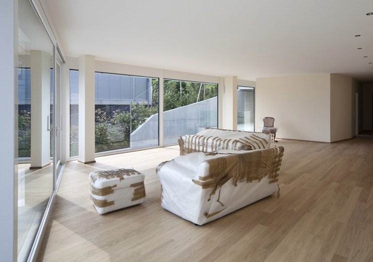 Остекленная панорамным оконными системами просторная комната, ламинат, стул