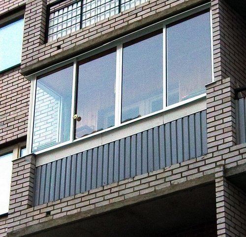 Застекленный балкон в многоэтажном кирпичном доме